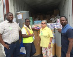 Jenny Tryhane with the 
                  PAWI Missions Director Pastor Forbes to her left, the Customs 
                  Officer on her left and The National Office of Disaster Services 
                  (NODS) ensuring that the container was safely delivered