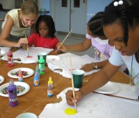 Seen below the children of Barbados hand-painting the Kisses from Heaven tee shirts