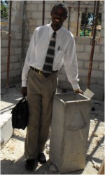 Seen here Pastor Rodrigues, trained by technitians at Clean Water for Haiti, standing beside the first filter produced in this small production plant.