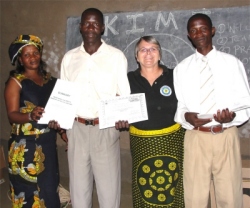 Patrick seen here receiving his certificate and KIMI manual and curriculum from Mama Pinos, (left) and Jenny. and Pastor Paul