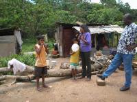 This is Indra's home - seen here with her mother, brother and Pastor Iwan.
