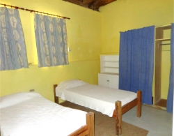 The leaders bedroom has two single beds, a waredrobe and chest of drawers