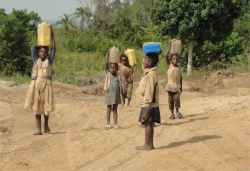 Children from the village walk for miles to collect water on the Land Sand Mining bore hole.