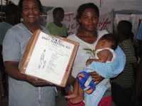 Seen here Dr. Yolader Thervil better known as Mama Yol helping with the distribution at a tent city