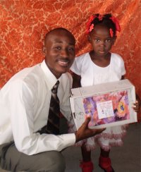 Daniel Noel distributed Make Jesus Smile shoeboxes at the Nazarene church in Goniave on Sunday morning.