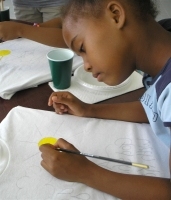 Seen below the children of Barbados hand-painting the Kisses from Heaven tee shirts