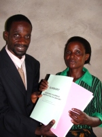 Pastor William the KIMI Uiliwa Coordinator handing out the KIMI curriculums and manual