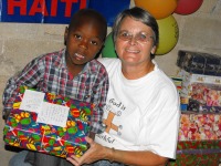 A litte boy at YWAM Gonieve.receiving his Make Jesus Smile shoebox