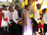 Seen here at their Harvest Festival bearing their Make Jesus Smile shoebox gifts as they brought them to the alter to 'Sow a seed of Love' for Haiti.