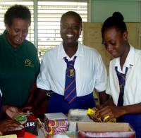 Seen here the head teacher (centre and below centre) with the United Caribbean South American Co Ordinator - Pauletter Scantlebury (left) and another pupil packing the last of the boxes.