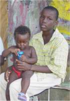 A child caring for a child in Soubise destroyed in hurricane Ivan