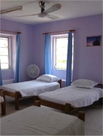 The east facing bedroom has five single beds. There are distant views of Skeetes Bay and the room is cooled by tropical sea breezes. 